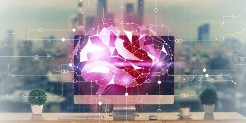Pink geometric AI brain displayed on a computer monitor, with circuit lines over a desk setup.