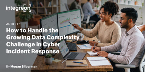 Two coworkers review charts on desktop screens in a modern office, illustrating an article about handling growing data complexity in cyber incident response.
