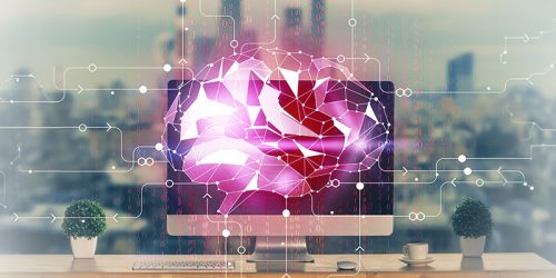 Pink geometric AI brain displayed on a computer monitor, with circuit lines over a desk setup.